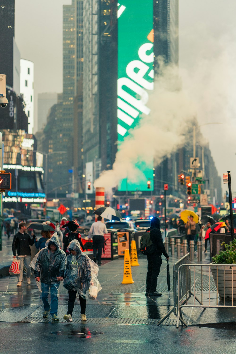 a group of people walking down a street next to tall buildings