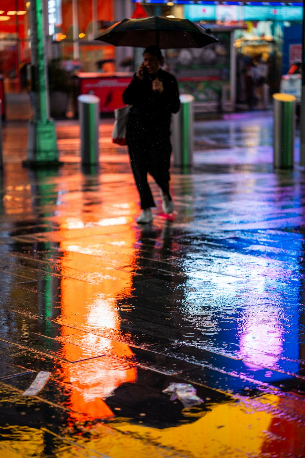 a woman walking down a street holding an umbrella