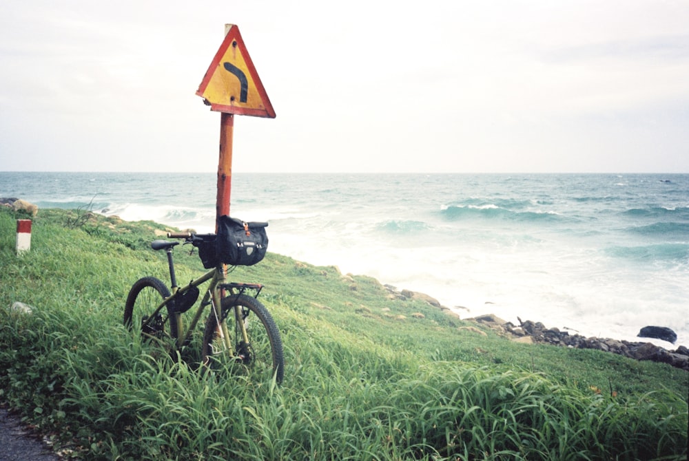 a bicycle leaning against a sign on the side of a road