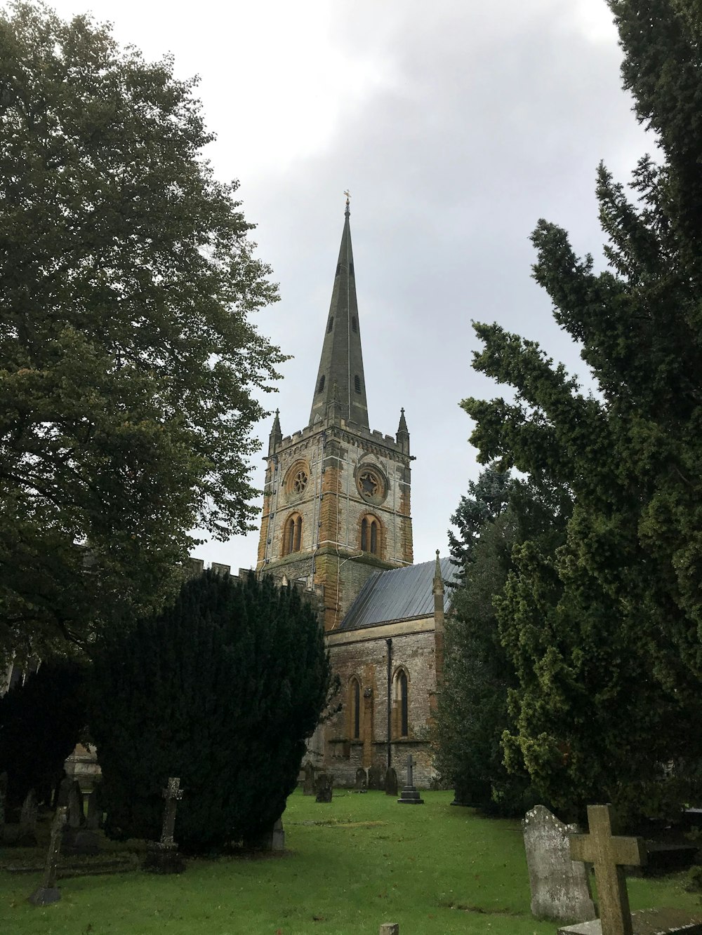 a church with a steeple surrounded by trees