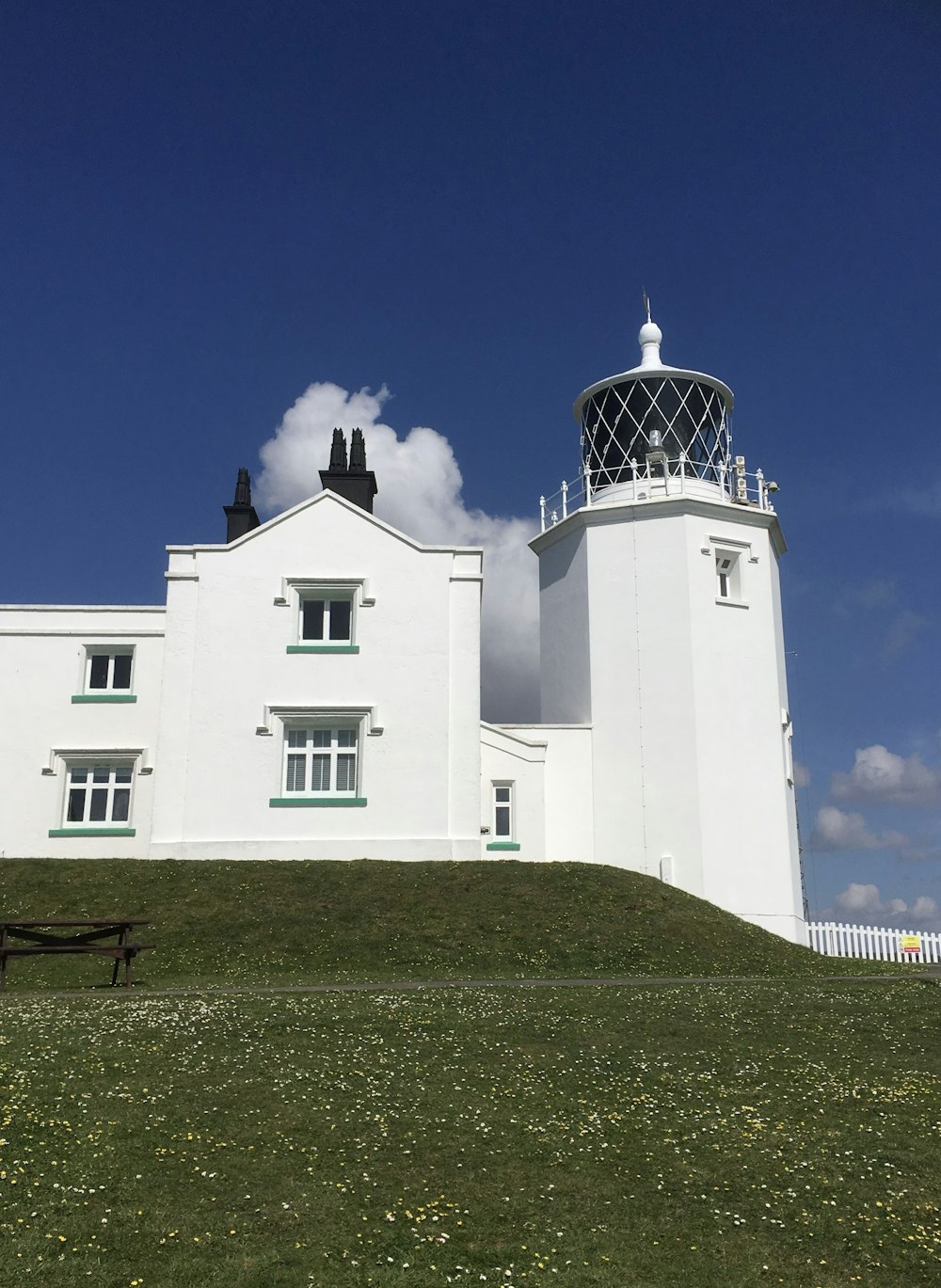 a large white building sitting on top of a lush green field