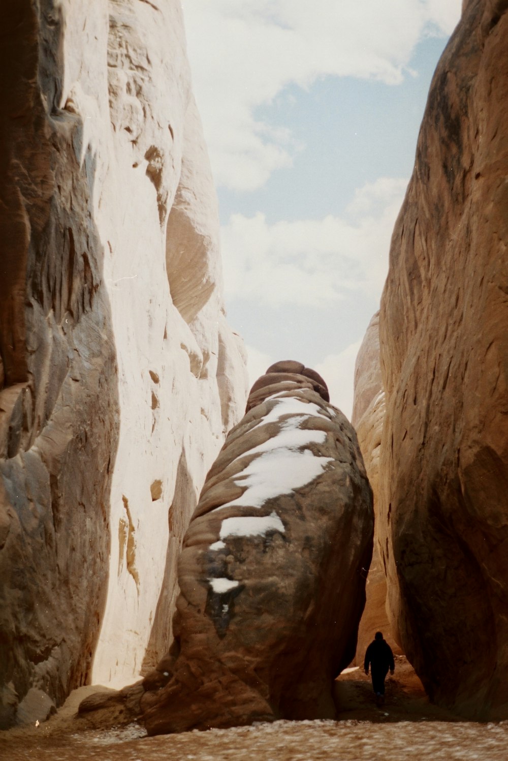 a man is standing between two large rocks