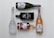 Five bottles of various alcoholic beverages are arranged neatly on a light background. The bottles include a white frosted glass vodka bottle, a black rectangular gin bottle, a brown glass whiskey bottle, and two bottles of sparkling wine with decorative labels.