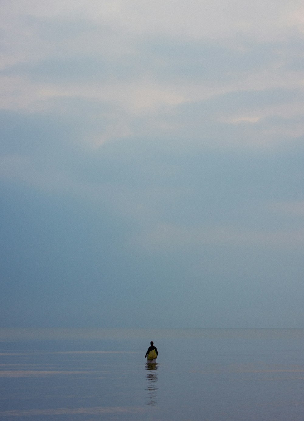 a person sitting on a surfboard in the middle of the ocean