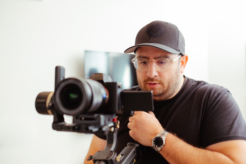 a man holding a camera in front of a video camera