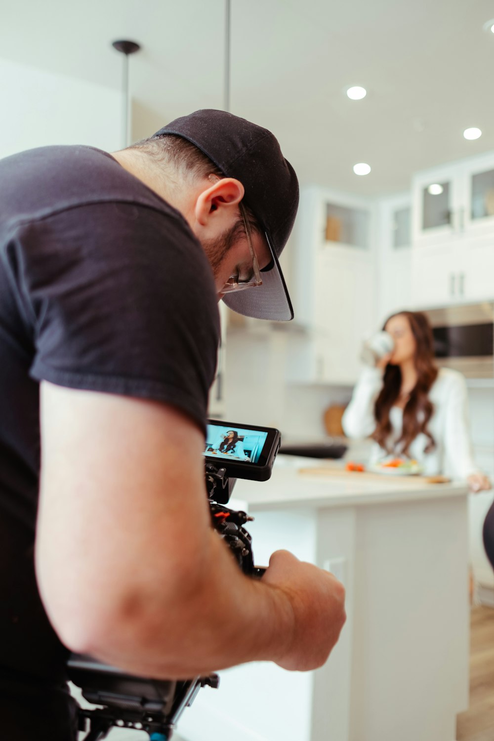 a man filming a woman in a kitchen