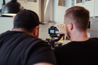 a man taking a picture of another man in a kitchen