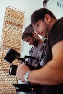 a man standing next to another man holding a camera