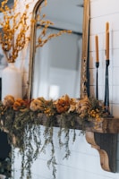 a mirror and some candles on a mantle
