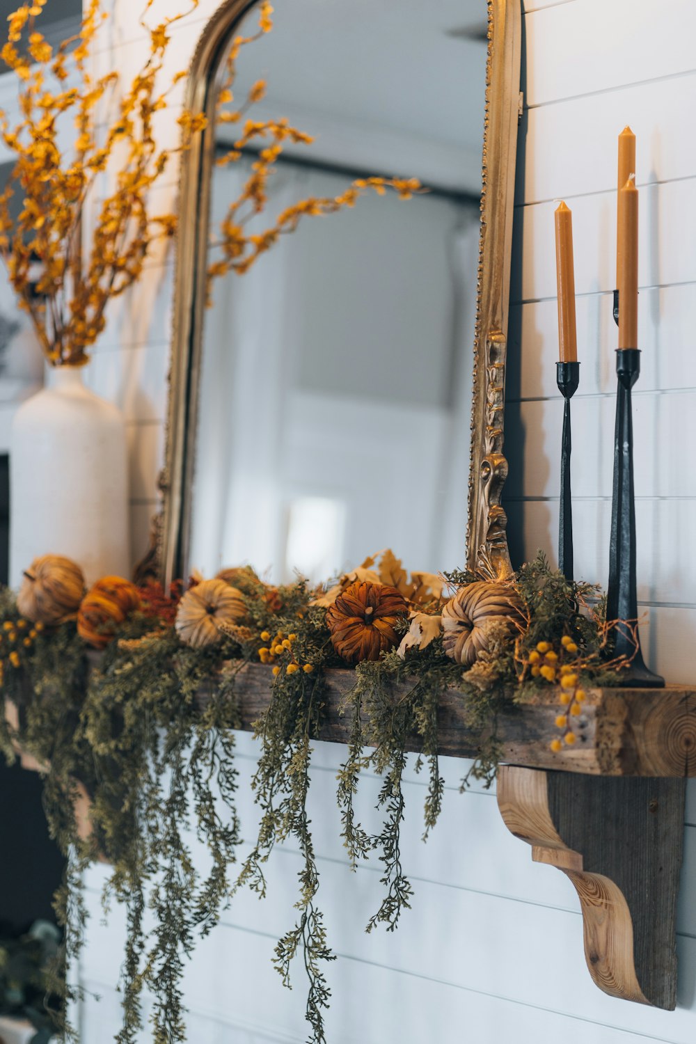 a mirror and some candles on a mantle