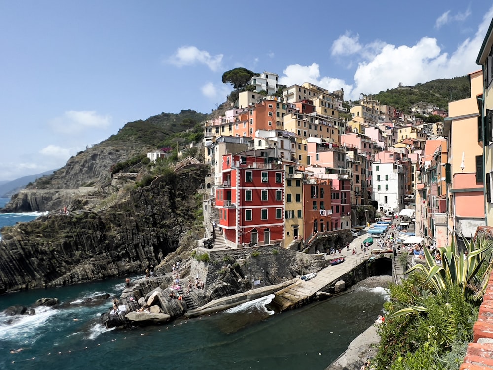 a group of buildings sitting on top of a cliff next to the ocean