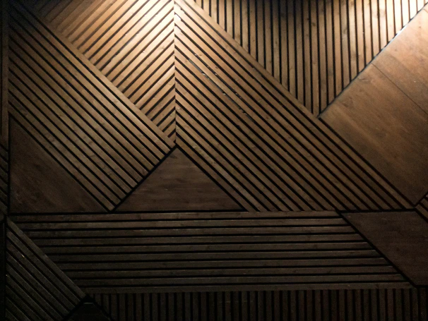 Finished wooden geometric panel mounted on a white wall, highlighting craftsmanship.