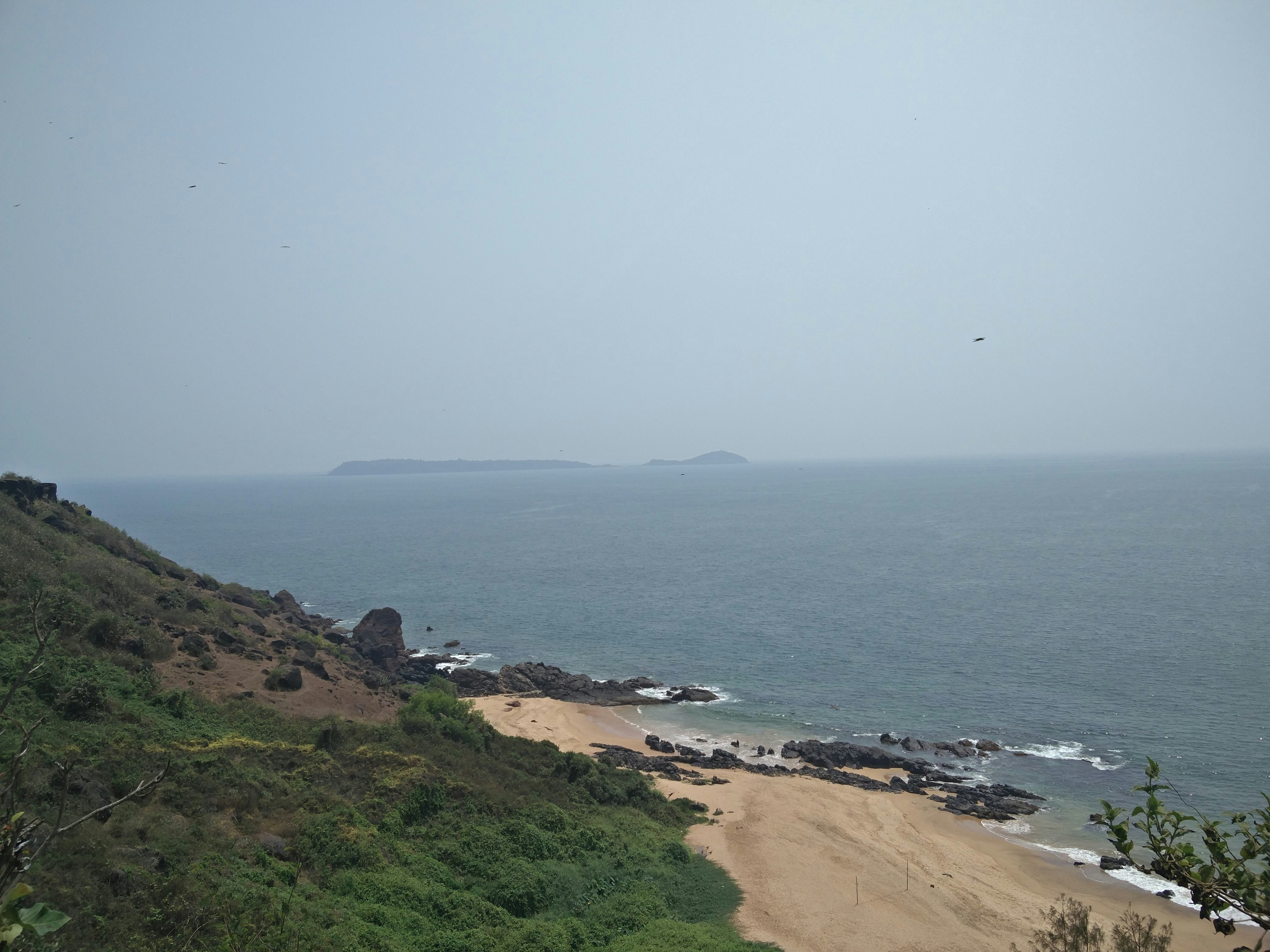 a view of the ocean from the top of a hill, A hidden beach in North Goa, India