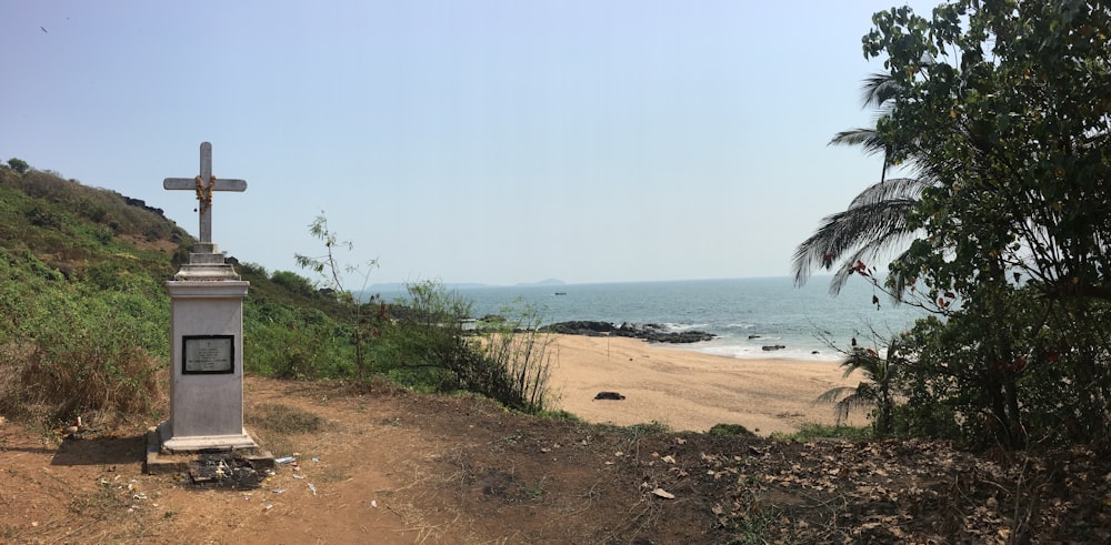 Una cruz en una colina con vistas a una playa