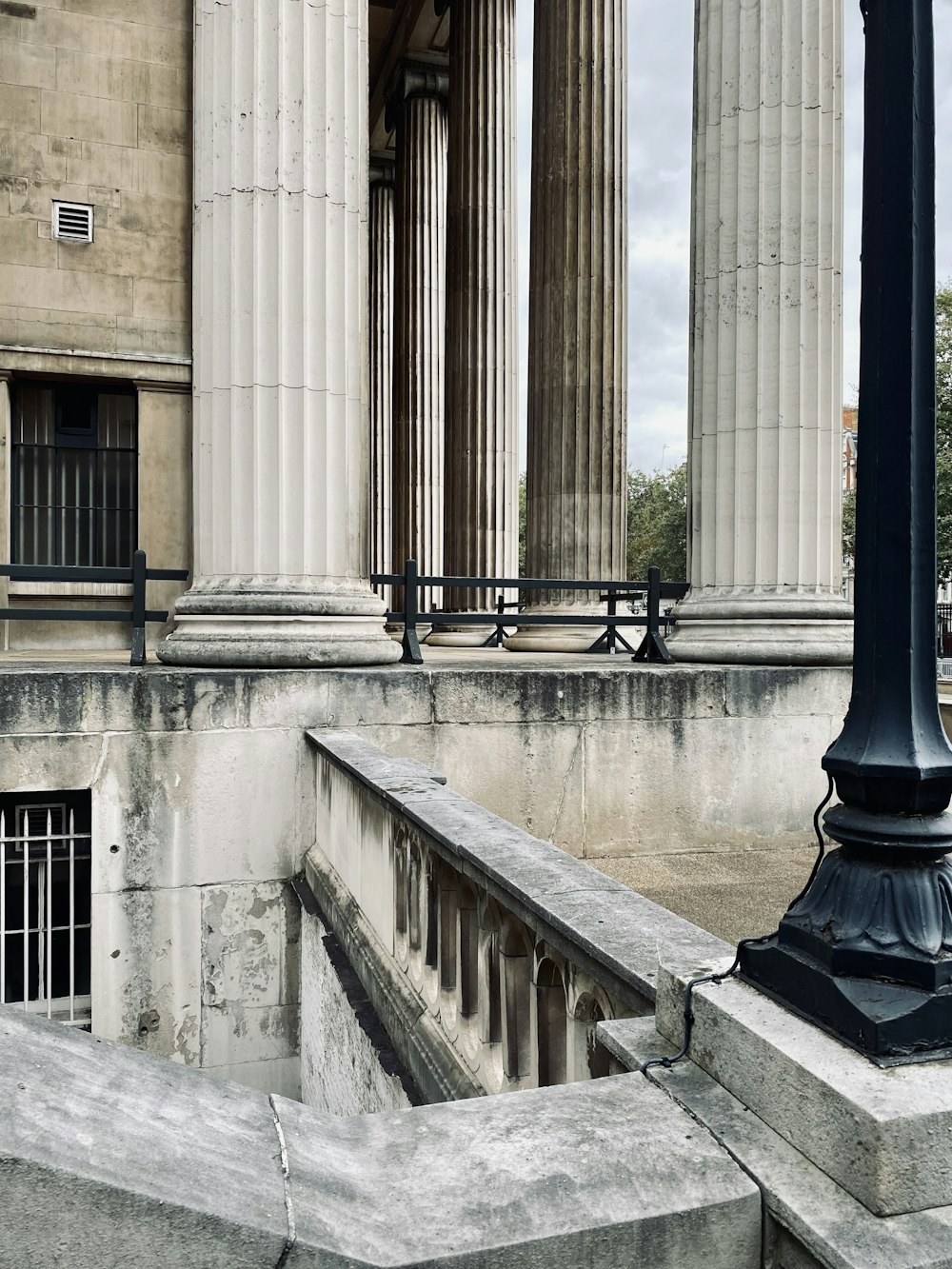a lamp post in front of a building with columns