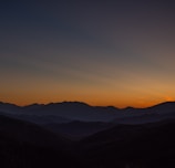 A serene nature documentary scene featuring a sunset over mountains.