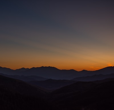 A serene nature documentary scene featuring a sunset over mountains.