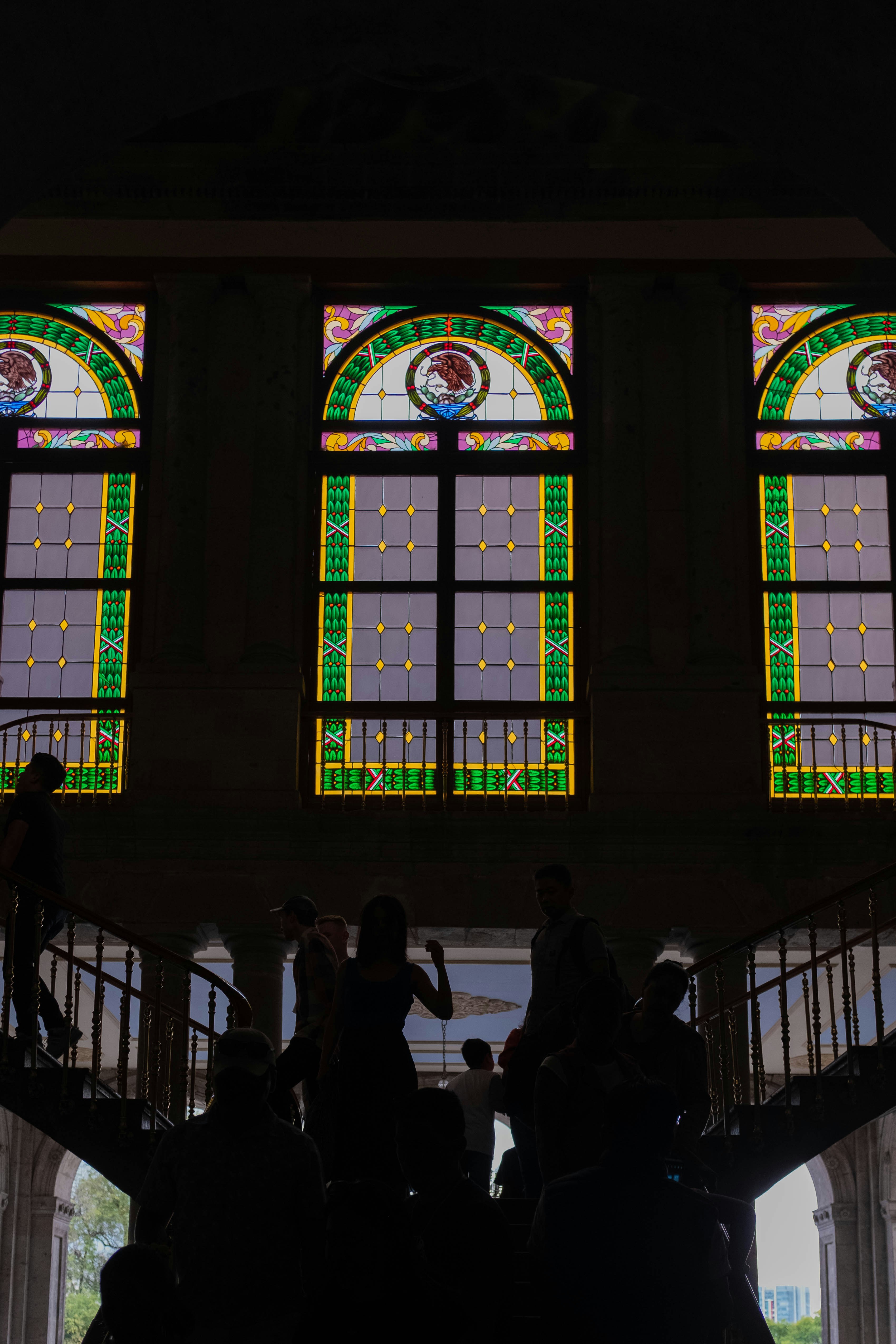 a group of people standing in front of a stained glass window