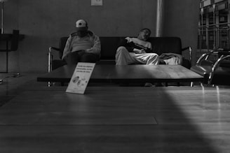 A cozy, sunlit room with two people sharing a peaceful nap on a plush couch.