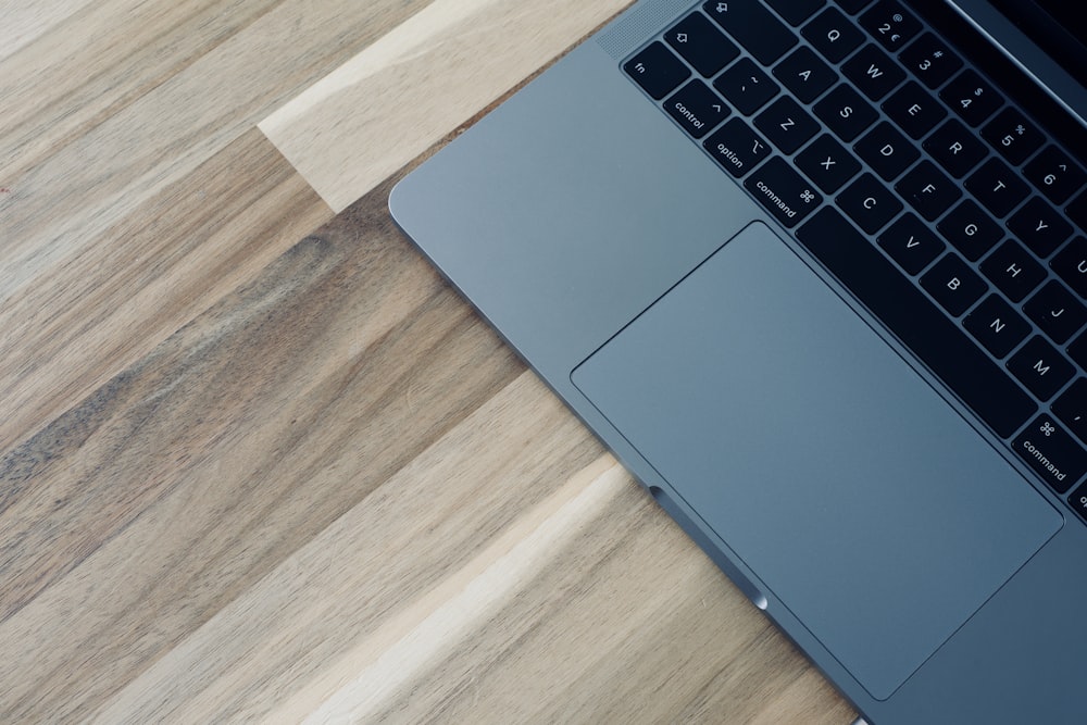 a laptop computer sitting on top of a wooden table