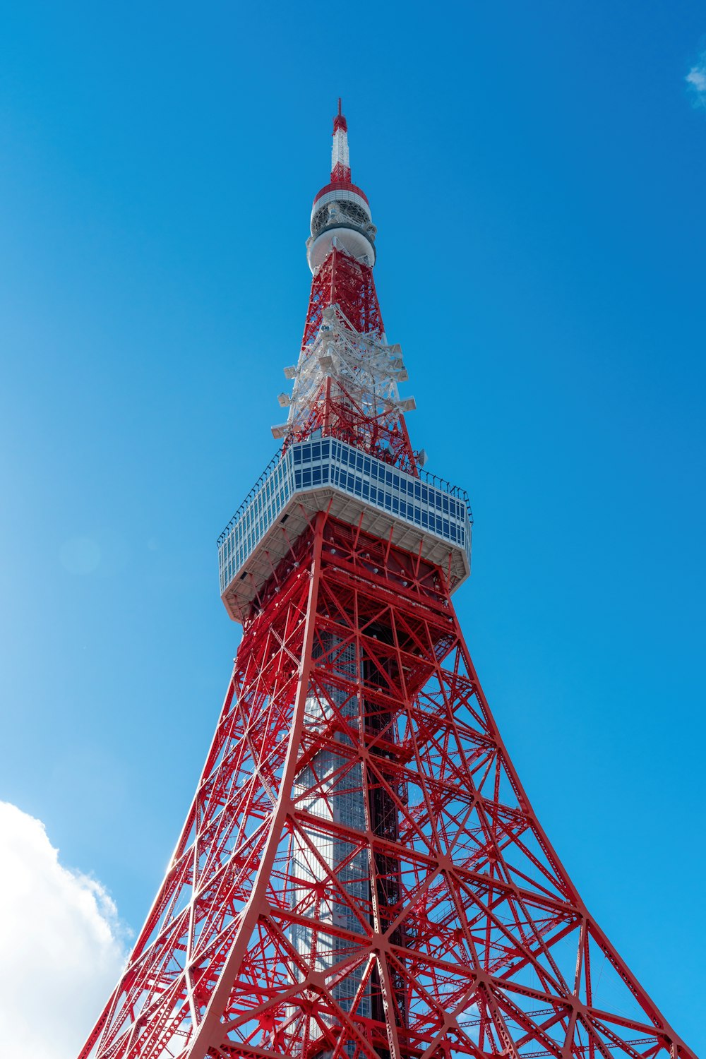 a very tall red and white tower under a blue sky