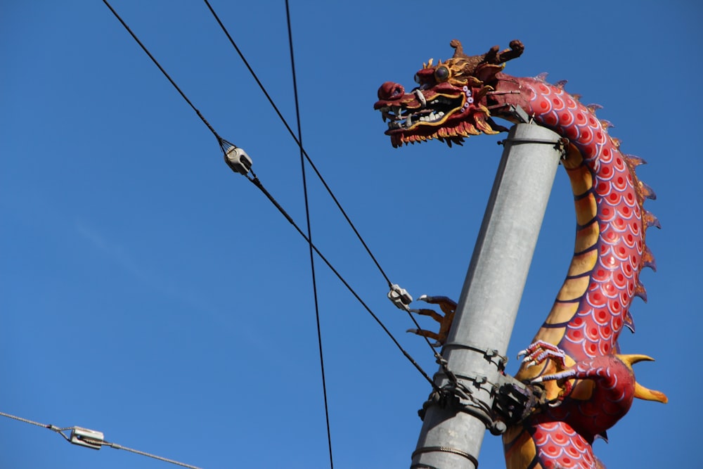 uma estátua do dragão no topo de um poste de metal