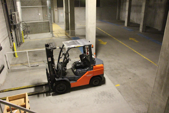 Forklift operator training session with students practicing in a warehouse environment.