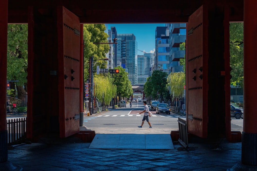 Un hombre caminando por una puerta abierta en una ciudad