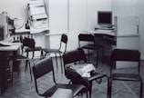 a black and white photo of a room with many chairs