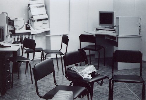 a black and white photo of a room with many chairs
