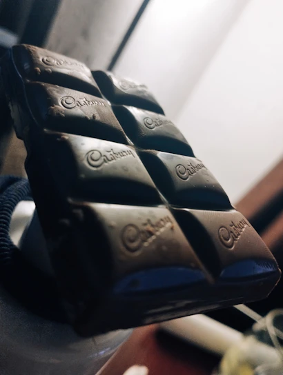 Close-up of a luxurious dark chocolate bar with glossy finish and intricate patterns