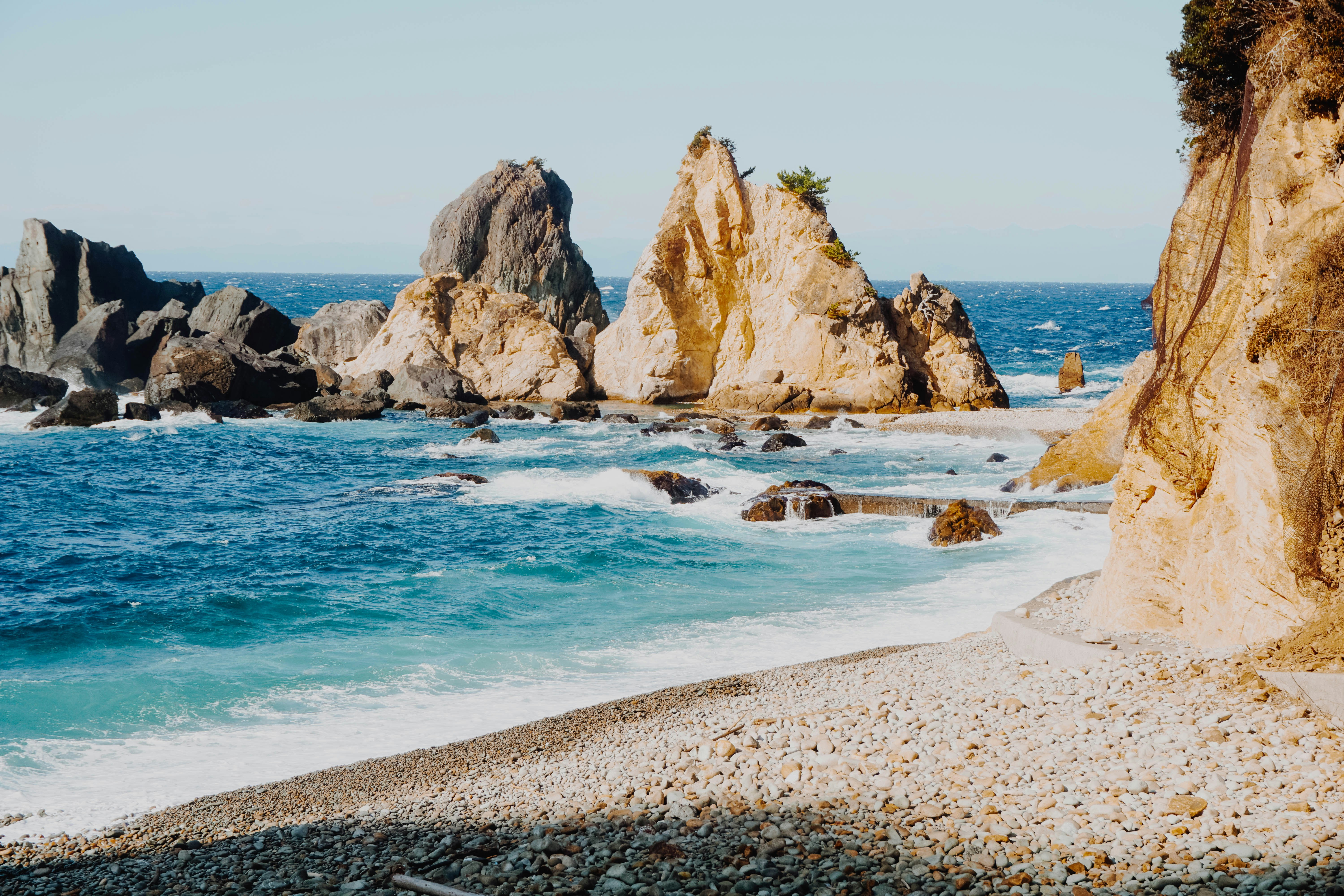 a rocky beach with a body of water next to it