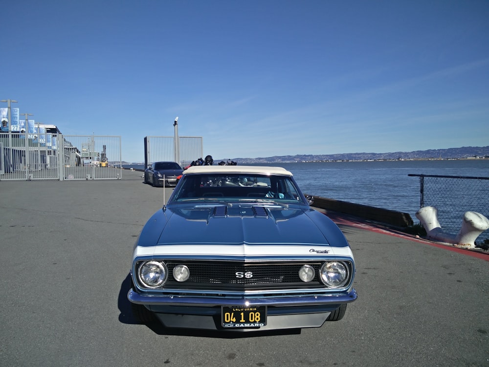 a blue and white car parked on the side of a road