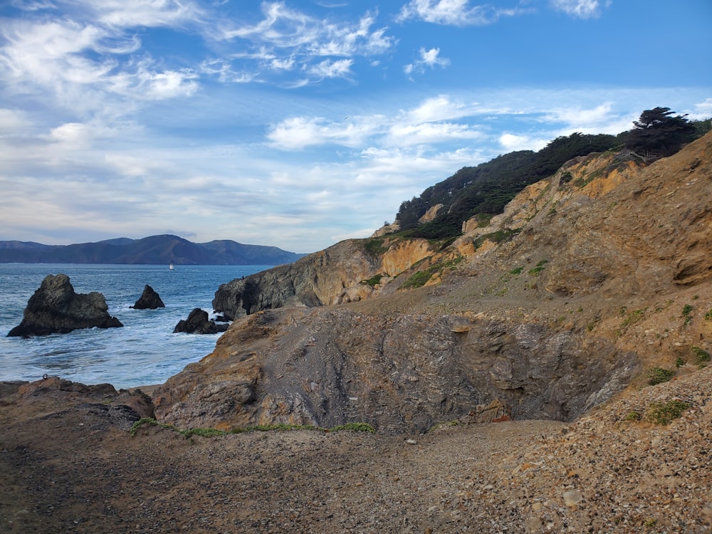 a bench sitting on the side of a cliff next to the ocean