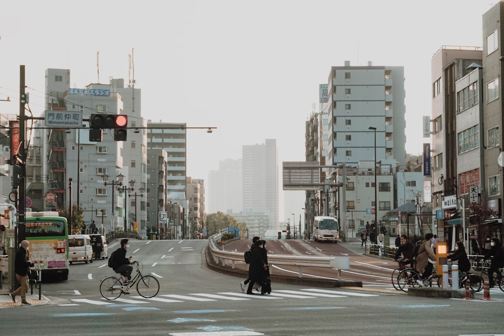 a couple of people crossing a street at a traffic light