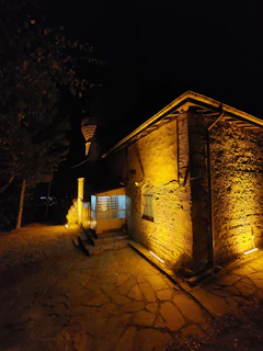 Evening shot of alameen nexus facility exterior, the terracotta walls glowing warmly under industrial lighting.