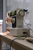 Various embroidery machine components laid out on a workbench.