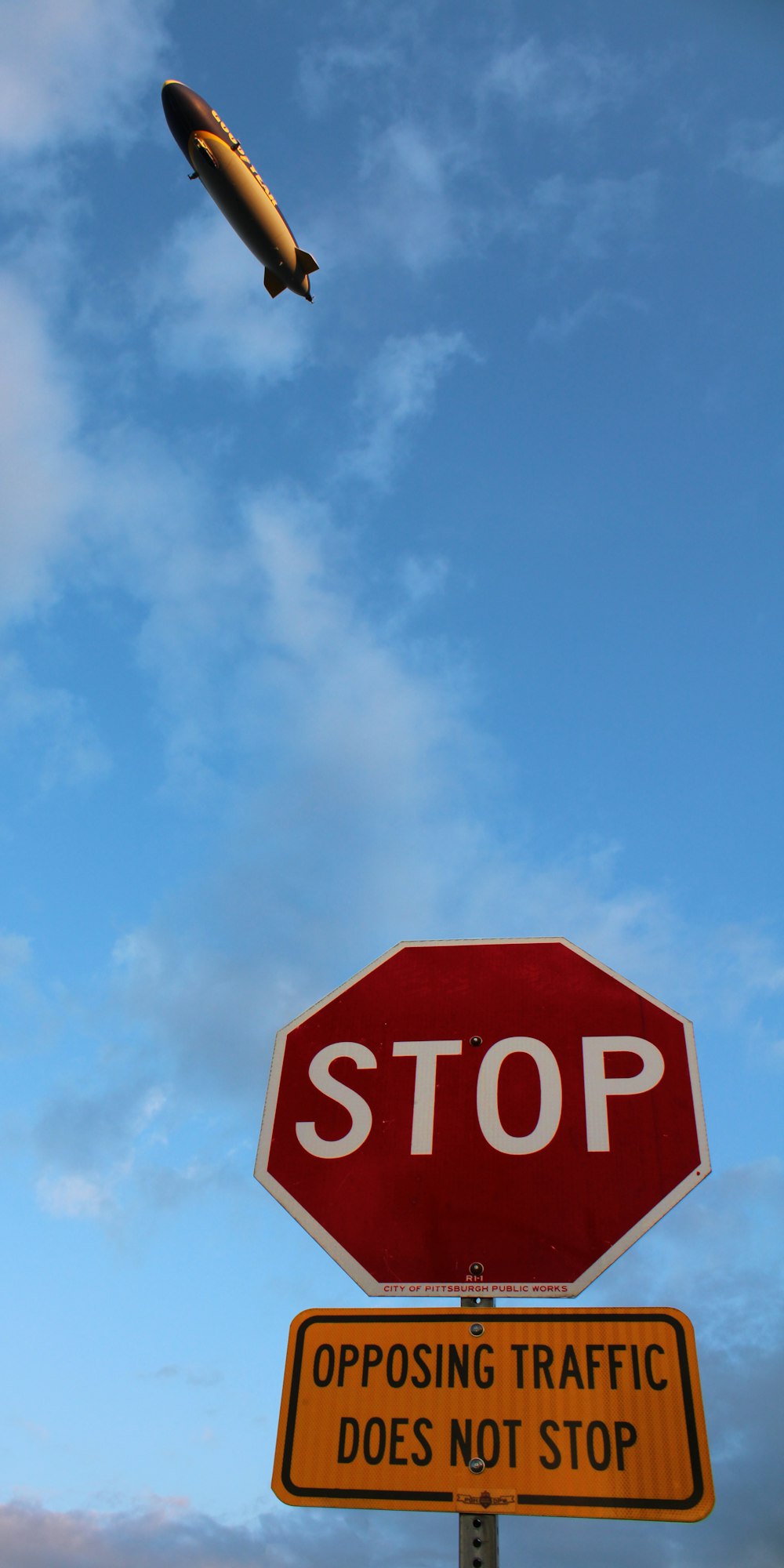 um sinal de parada vermelho sentado sob um céu nublado azul