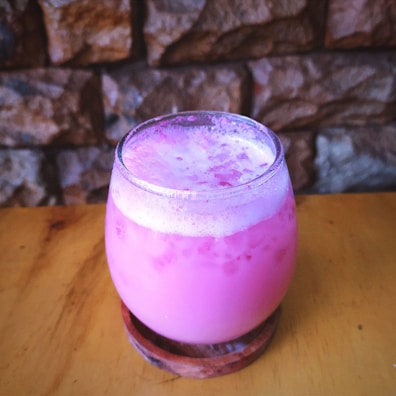 Bright pink soda in a clear glass, matching the café’s fiucsa color theme.