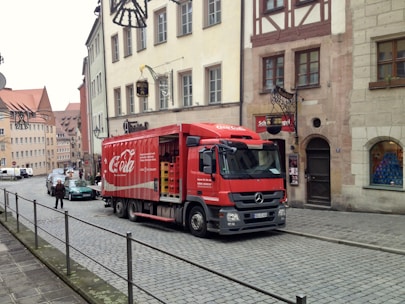 Delivery truck on a highway with European landmarks in the background.