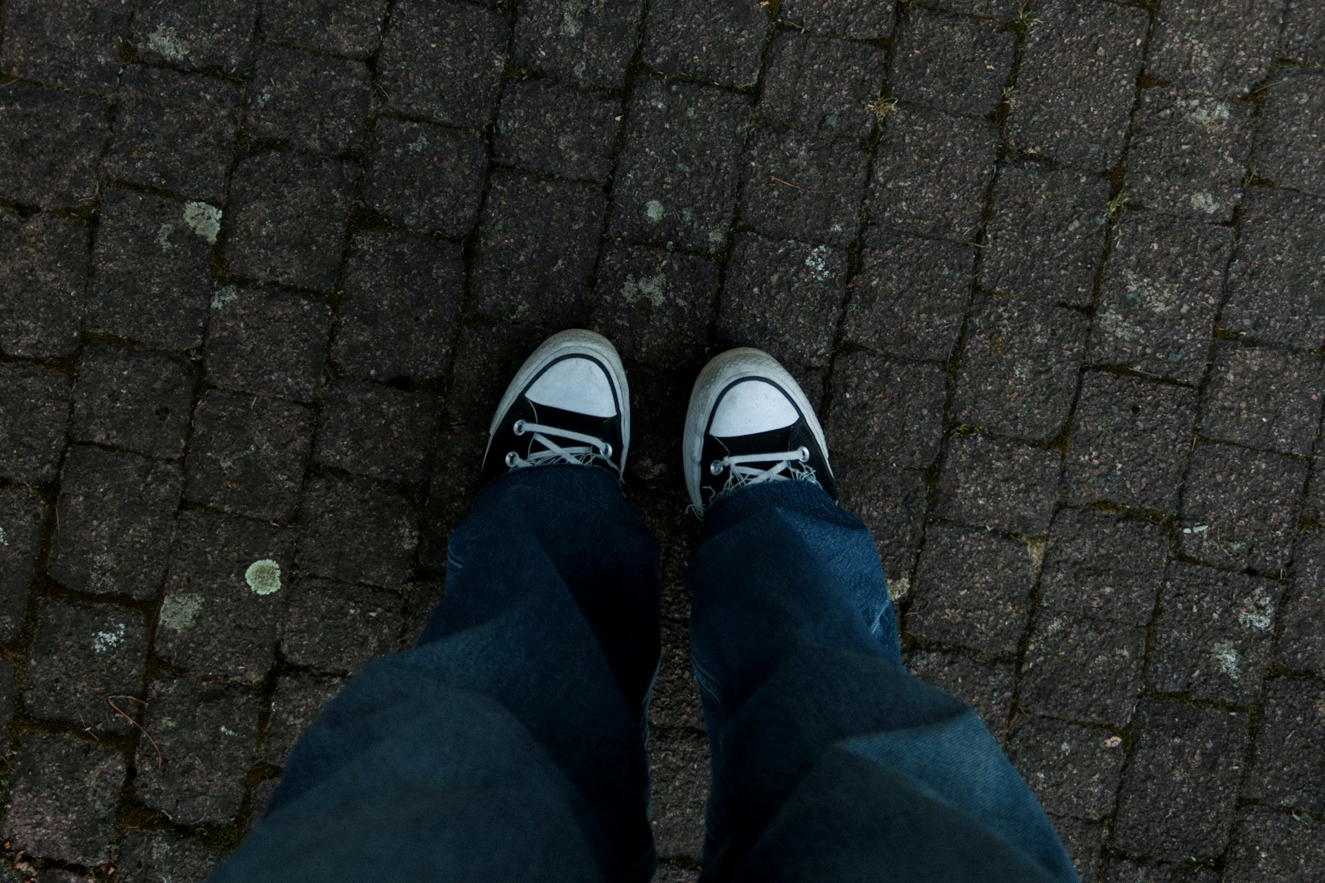 a person standing on a sidewalk with their shoes on