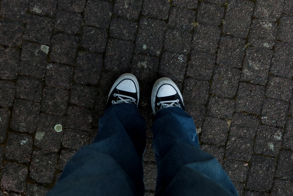 a person standing on a sidewalk with their shoes on