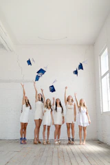 A group of female students collaborating on a graduation project in a bright classroom.