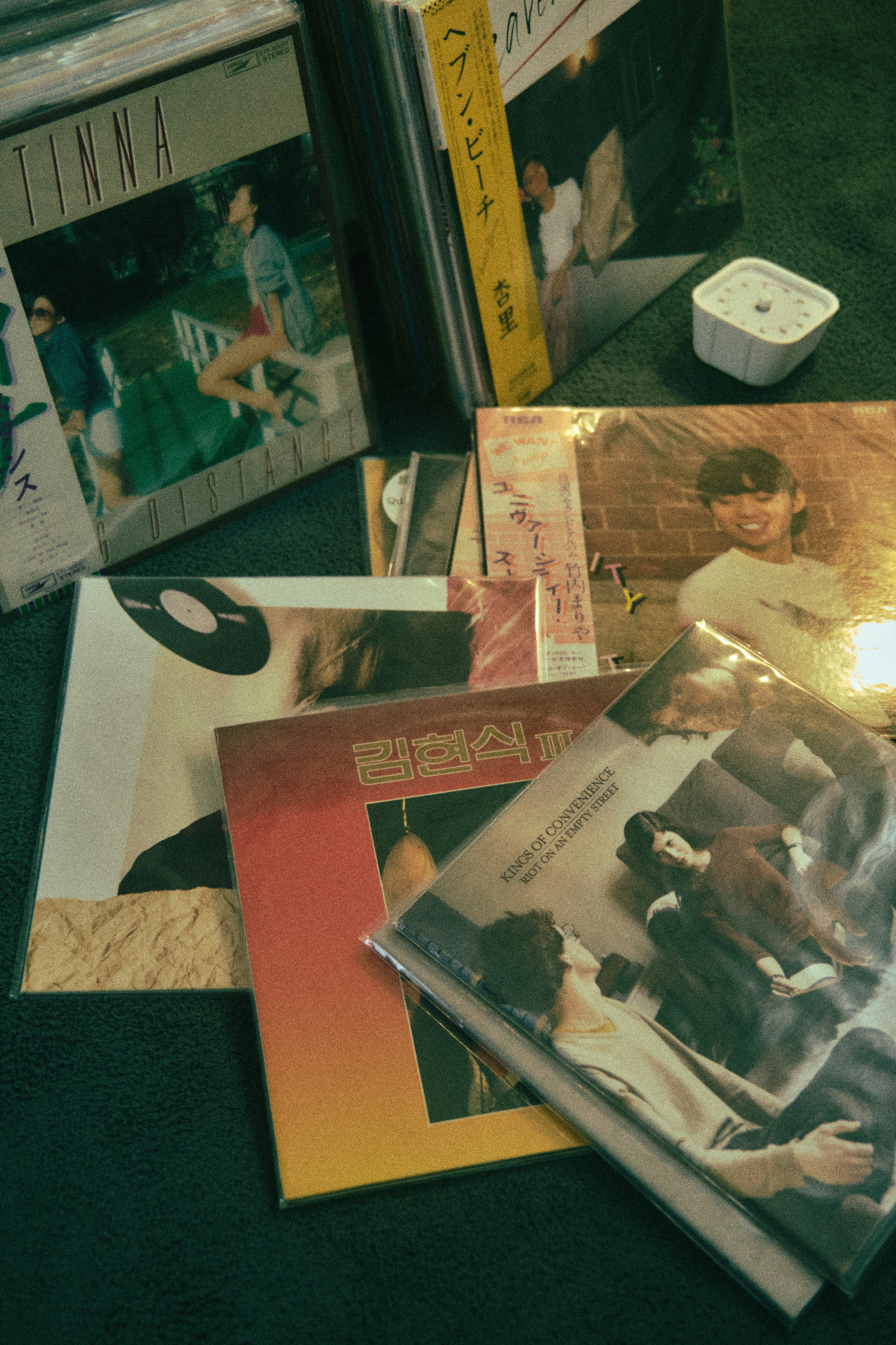 Una pila di CD seduti sopra un tappeto verde