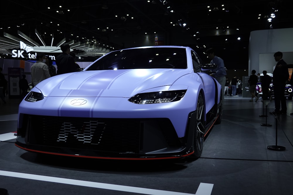 a blue sports car on display at a car show