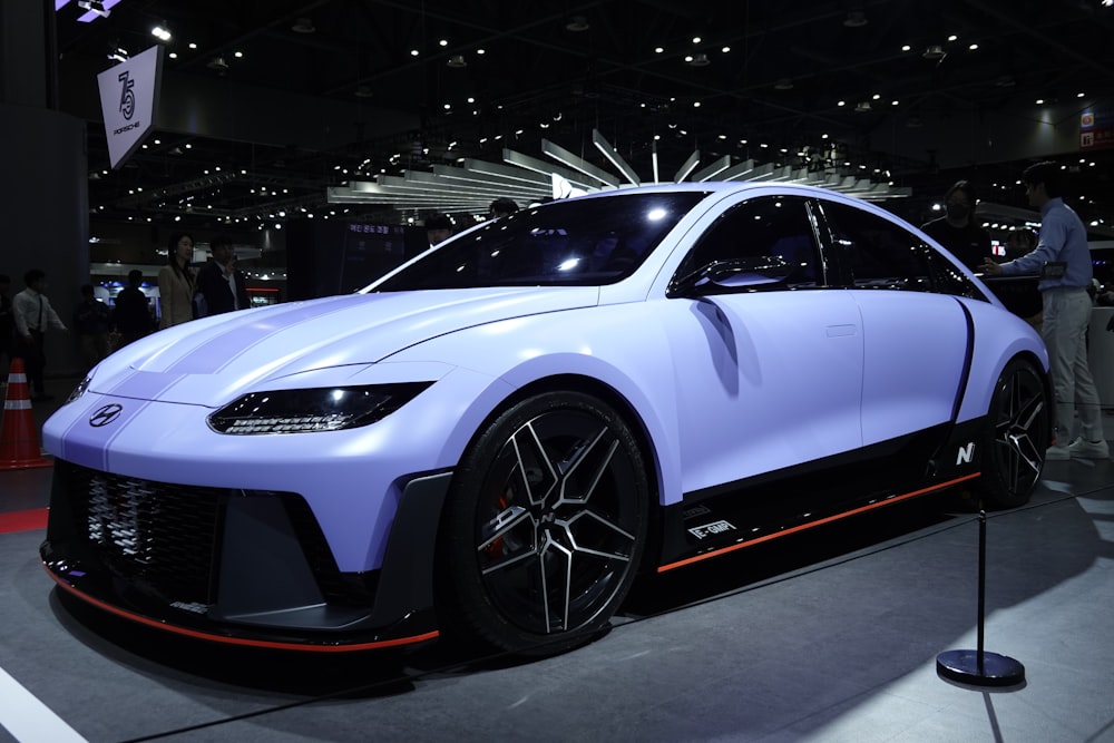 a blue sports car on display at a car show