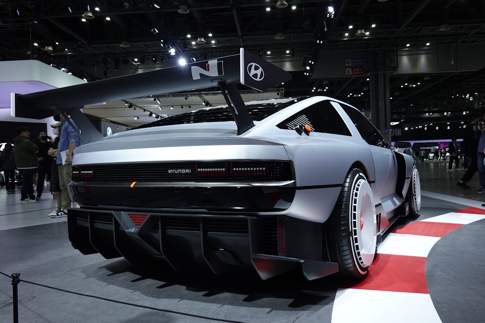 a silver sports car on display at a car show