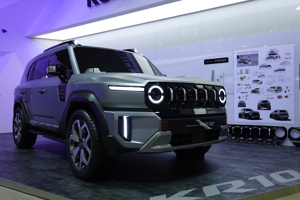 a grey jeep is on display in a showroom