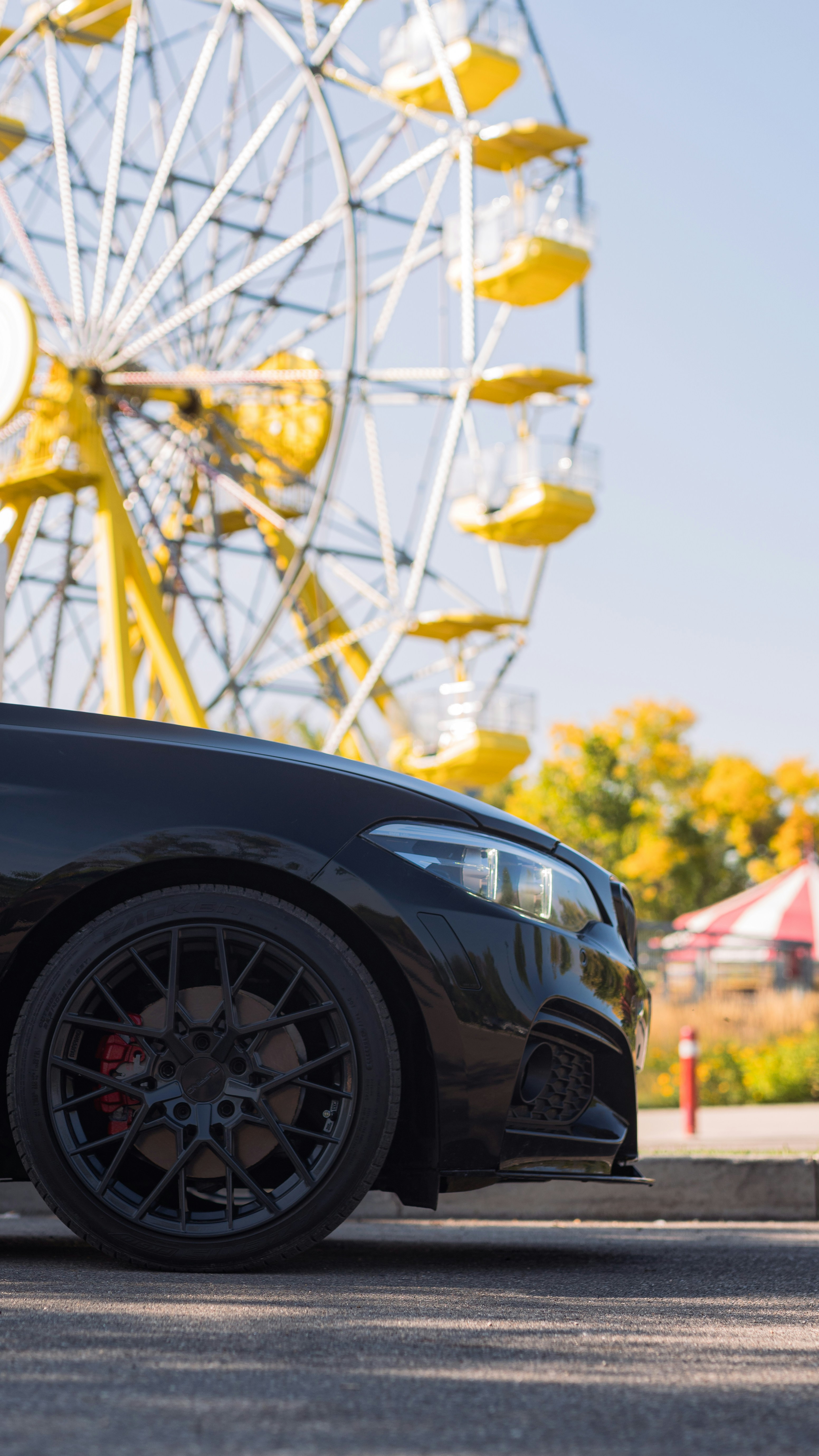 a car parked in front of a ferris wheel