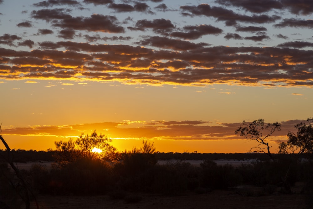 the sun is setting in the sky over the desert